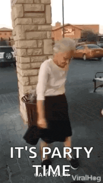 Elderly Woman Dancing in Brick Building Parking Lot