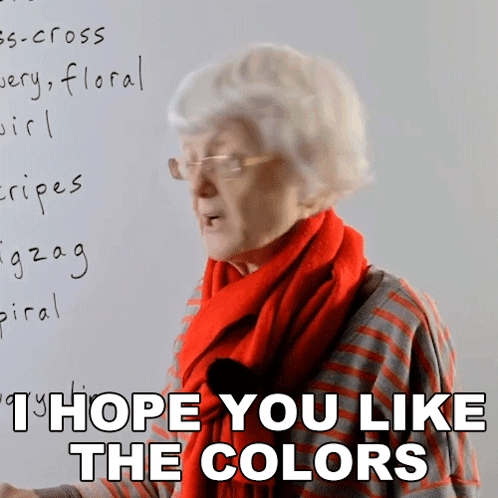 Elderly Woman in Glasses and Red Scarf Says I Hope You Like the Colors
