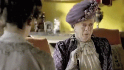 Elderly Woman in Purple Hat Talking to Another Woman