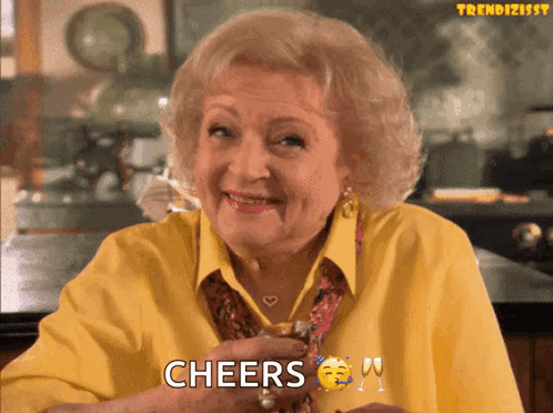 Elderly Woman In Yellow Shirt Cheers With Wine GIF