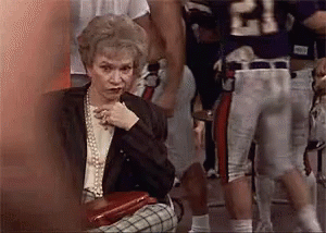 Elderly Woman Sitting in Front of Football Player Number 21