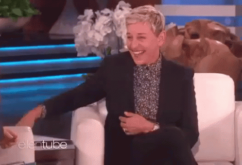 Ellen Degeneres Is Laughing While Sitting In A Chair On Ellentube GIF