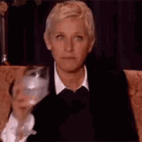 Ellen Degeneres Is Sitting On A Couch With A Glass Of Wine . GIF