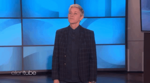 Ellen Degeneres Is Standing In Front Of A Blue Wall On Ellentube GIF