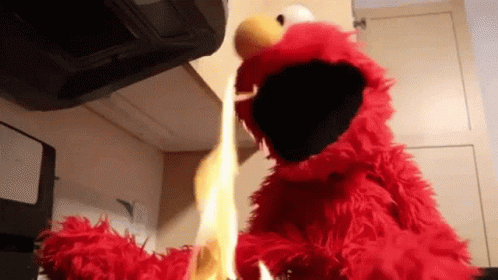 Elmo From Sesame Street Is Holding A Flame In His Hands GIF