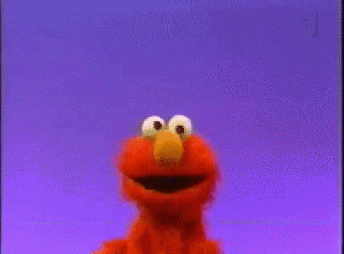 Elmo From Sesame Street Is Smiling And Looking At The Camera Against A Purple Background . GIF