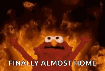 Elmo From Sesame Street Is Standing In Front Of A Fire . GIF