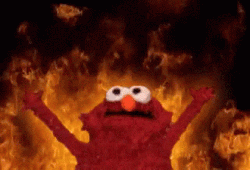 Elmo From Sesame Street Is Standing In Front Of A Fire With His Arms Outstretched . GIF