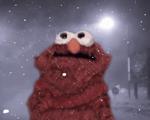 Elmo From Sesame Street Is Standing In The Snow In Front Of A Sign That Says No Parking GIF