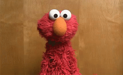 Elmo From Sesame Street Says " I 'M An Idiot " In Front Of A Wooden Background GIF