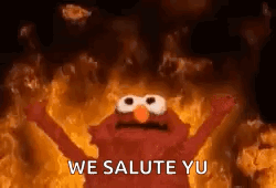 Elmo Is Standing In Front Of A Fire With His Arms Outstretched . GIF