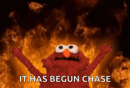 Elmo Is Standing In Front Of A Fire With The Words `` It Has Begun Chase '' Written On It . GIF