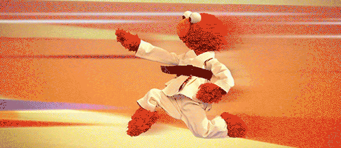 Elmo Is Wearing A White Karate Uniform With A Black Belt Around His Waist GIF