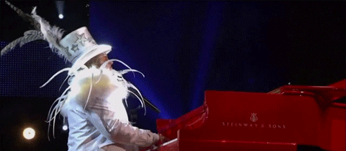 Elton John Wearing Matching White Outfit And Hat GIF