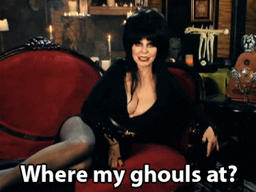 Elvira Lying On A Red Couch GIF