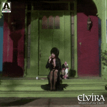Elvira Sitting With Her Dog On A Staircase GIF