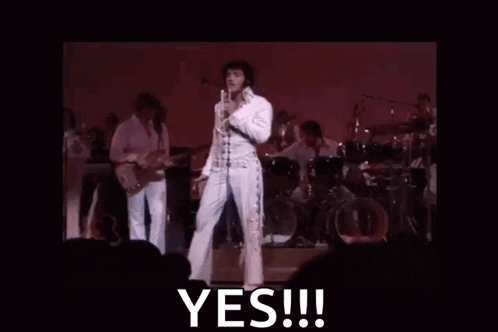 Elvis Presley Is Standing On A Stage Holding A Microphone And Says Yes GIF