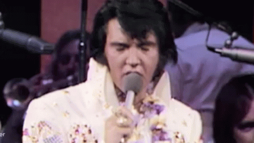 Elvis Presley Singing Into Microphone in White Suit