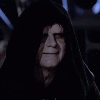 Emperor Palpatine From Star Wars Is Wearing A Hooded Robe And Looking At The Camera In The Dark . GIF