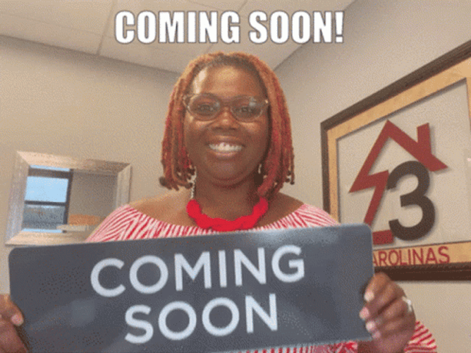 Excited Lady Showing Coming Soon Sign GIF