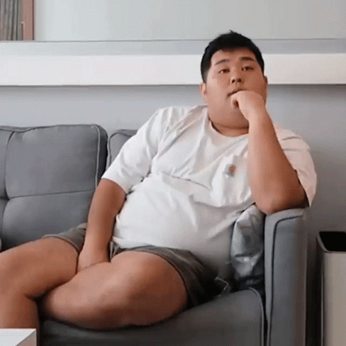 Fat Man Sitting on Couch Hand on Chin