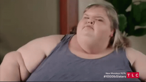 Fat Woman In Blue Tank Top Making Funny Face On Couch GIF