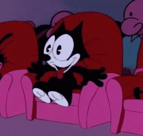 Felix The Cat Is Sitting In A Pink Chair In A Theater . GIF