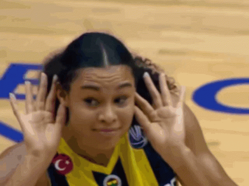 Female Basketball Player Covering Ears In Yellow Jersey GIF