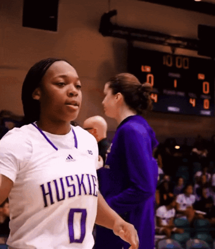 Female Basketball Player in Huskies Jersey Walking
