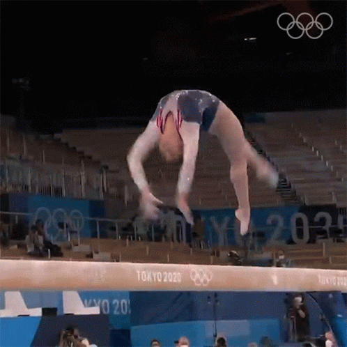 Female Gymnast Performing Balance Beam Trick