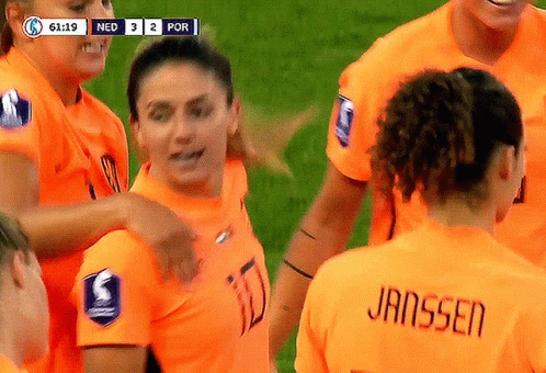 Female Soccer Players Huddled, Janssen on Jersey