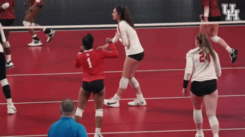 Female Volleyball Players Celebrating on Red Court