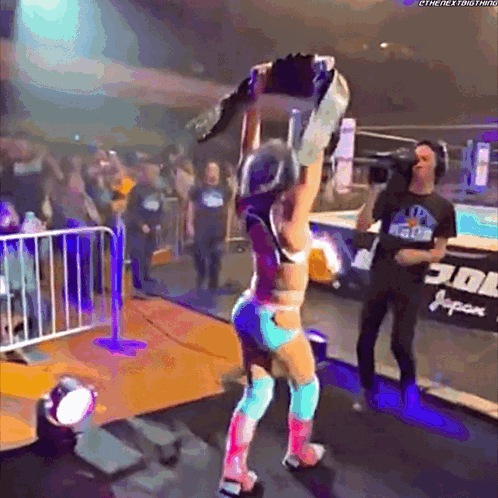 Female Wrestler Holding Championship Belt Over Head