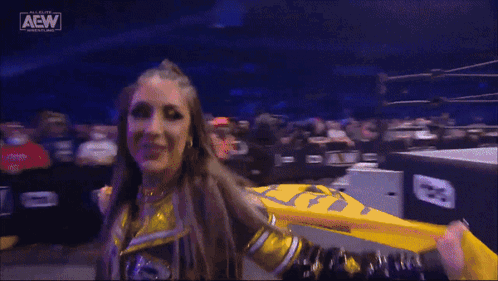 Female Wrestler Holding Yellow Flag In Front Of Crowd GIF
