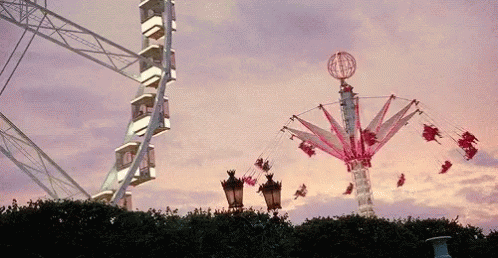 Ferris Wheel and Merry Go Round Against Pink Sky