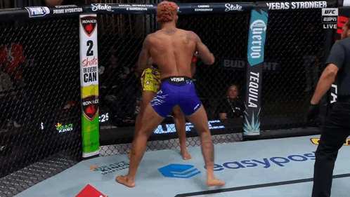 Fighter In Purple Shorts In Front Of Shots In Every Can Sign GIF