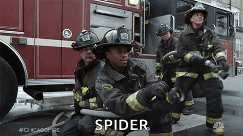 Firefighters Kneeling With Hose In Front Of Truck GIF