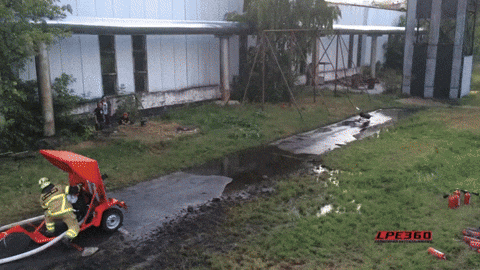 Fireman Splash Water At Flamethrower Using Fire Hose GIF