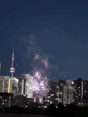 Fireworks Are Displayed In The Night Sky Over A City Skyline GIF