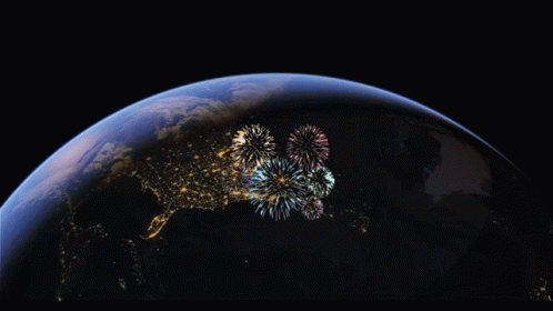 Fireworks Are Displayed Over The Earth In A Dark Sky GIF