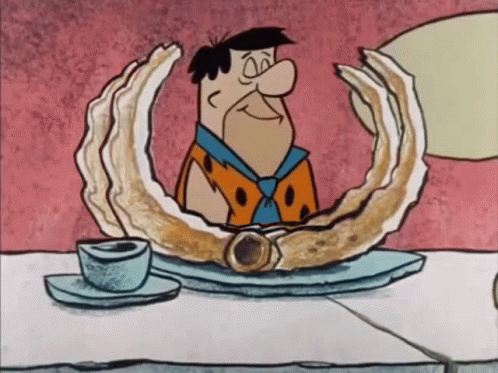 Flintstone Sitting at Table With Oyster