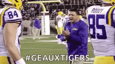Football Coach Talking to Players in Geauxtigers Shirt