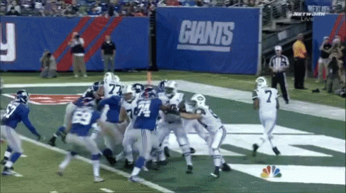 Football Game Under Giants Sign
