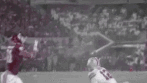 Football Player Catching Ball While Being Tackled