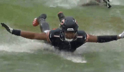 Football Player Flying Through Air Holding Ball GIF