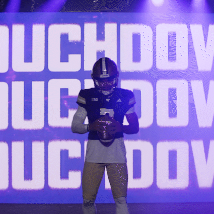 Football Player Holding Ball in Front of Duchov Sign