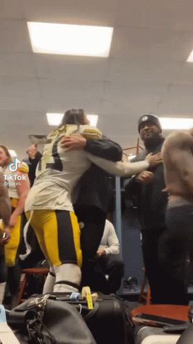 Football Player Hugging Another Player In Locker Room GIF