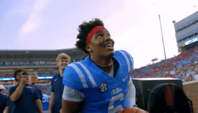 Football Player in Blue Jersey Number 5 Holding Basketball