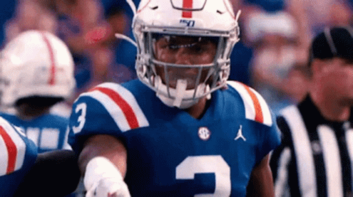Football Player in Blue White Red Uniform Standing Before Referee