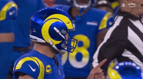 Football Player in Blue Yellow Helmet Pointing at Referee